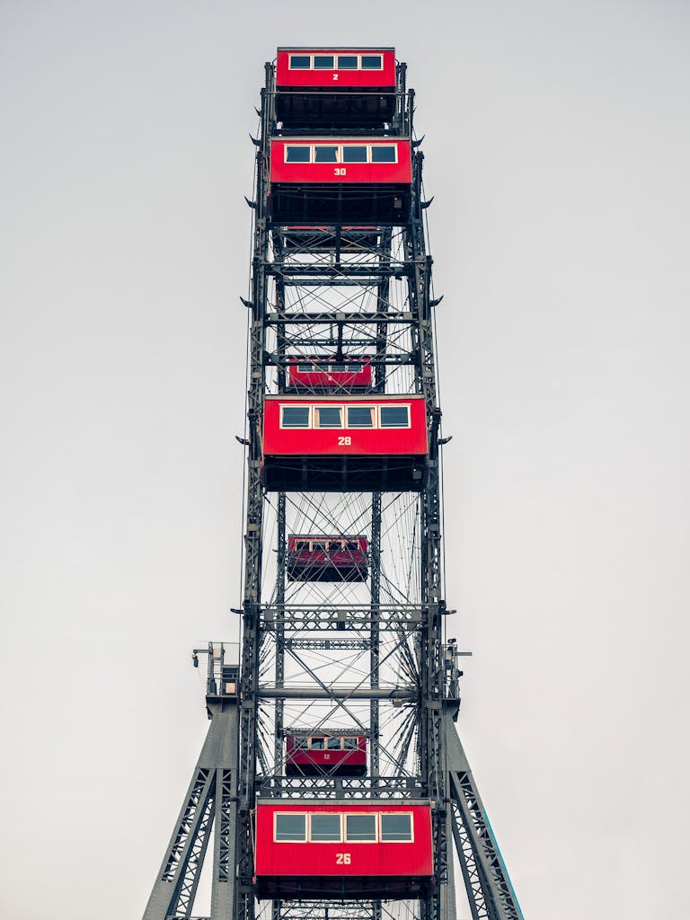Red cabins of the iconic Ferris wheel in Vienna, Austria, seen against a clear sky.